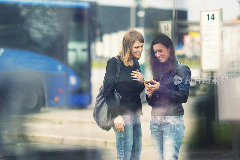 Young women waiting on the bus station